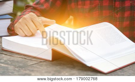 Closeup a hand for man reading a book at table outdoor.
