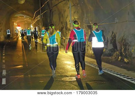 STOCKHOLM SWEDEN - MAR 25 2017: Rear view of many runners in reflex vest in a dark tunnel in the Stockholm Tunnel Run Citybanan 2017. March 25 2017 in Stockholm Sweden