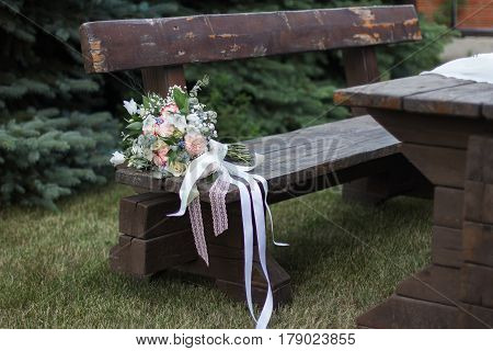 Wedding bouquet of yellow and white roses and blue fresia lying on wooden floor.