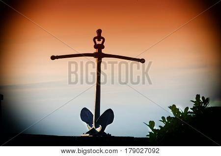 Old rusty ship anchor on a wall.
