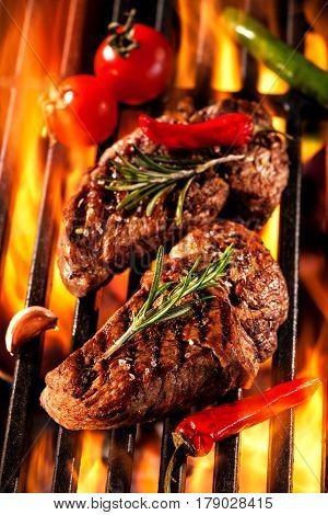 Beef steaks on the grill with flames