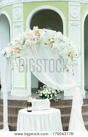 Table with champagne stands behind a beautiful wedding altar