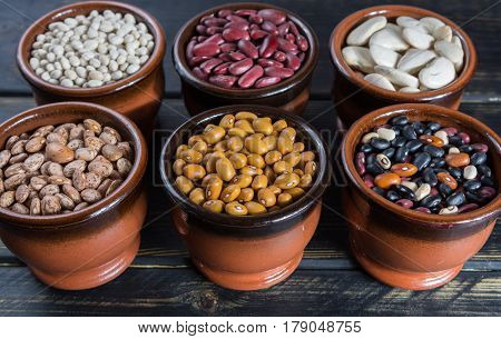Assortment of beans on black wooden background. Soybean red kidney bean black beanwhite bean red bean and brown pinto beans