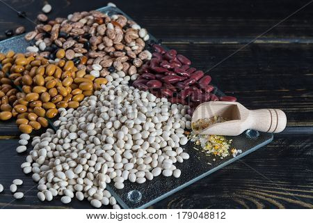 Assortment of beans on black wooden background. Soybean red kidney bean black beanwhite bean red bean and brown pinto beans