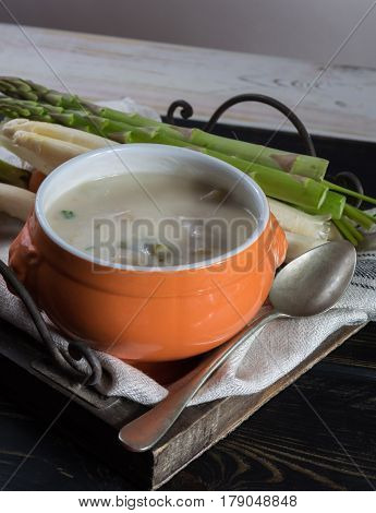 Spring season - white and green fresh asparagus cream- soup ready to eat with vegetables