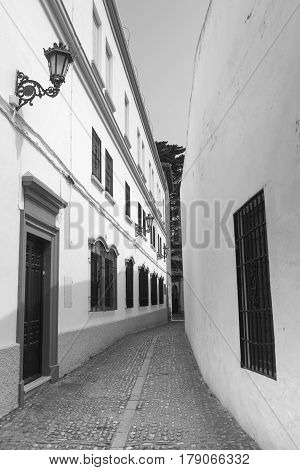 Ronda (Andalucia Spain): old typical street with white houses. Black and white