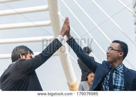 Two businessmen slapped hands during completed business plan talking with in city.
