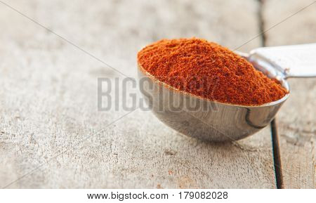 Powdered red pepper pile close up on wood