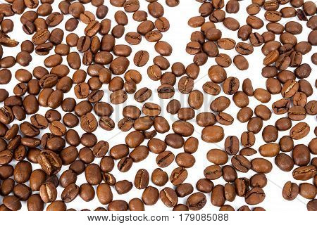Line of roasted coffee beans isolated in white background selective focus on the center