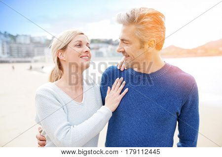 Middle-aged couple walking together on a sandy beach