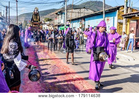 Antigua, Guatemala - March 19 2017: Locals reenact biblical scenes walking over handmade carpets during Lent procession in colonial town with most famous Holy Week celebrations in Latin America.