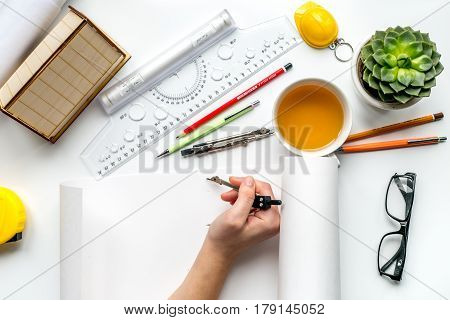 architect office with tools, hands, glasses and cup in profession concept on white desk background top view