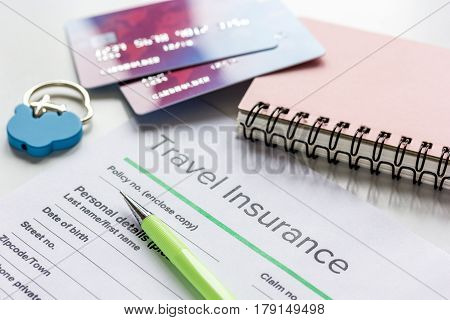 Travel insurance application form with credit cards on white desk background