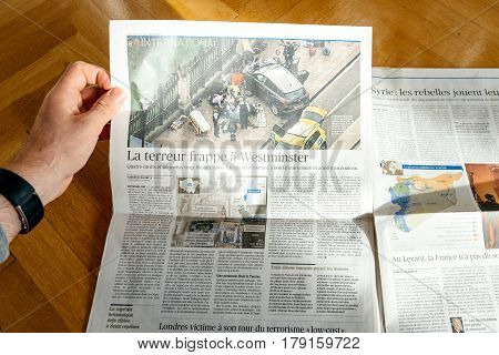 PARIS FRANCE - MAR 23 2017: Man reading French Le Figaro newspaper featuring headlines following the terrorist incident in London at the Westminster Bridge