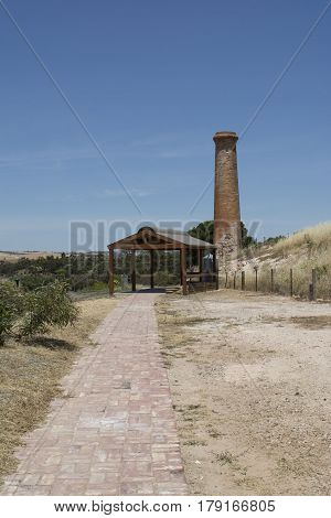 Kapunda South Australia Australia - December 3 2016: Old historic chimney built in 1850 at the Kapunda Copper Mine. Also featuring the newer shelter and paved path that leads to it. Portrait orientation.