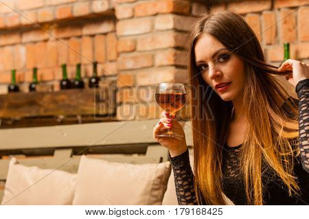 Woman Tasting Wine In Rural Cottage Interior