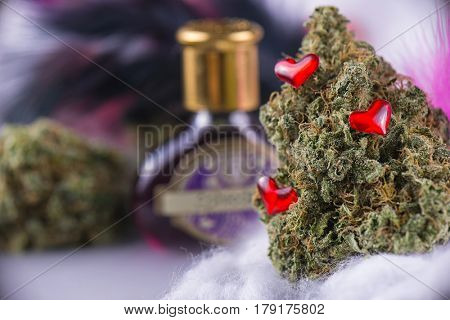 Macro detail of cannabis bud (love potion marijuana strain) with feathers and smoky background