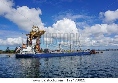 Labuan,Malaysia-Mac 25,2017:A large bulk carrier supplying iron ore in Antara Steel Mill Plant port at Labuan,Malaysia.The company produces billets and bars including angle bars and U-channels.