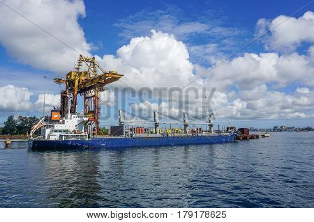 Labuan,Malaysia-Mac 25,2017:A large bulk carrier supplying iron ore in Antara Steel Mill Plant port at Labuan,Malaysia.The company produces billets and bars including angle bars and U-channels.