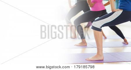 Low section of class and instructor doing stretching pilate exercises in fitness studio