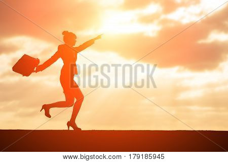 silhouette of businesswoman show something with sunset
