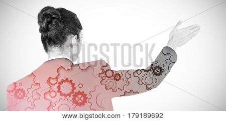 Rear view of businesswoman using digital screen against grey background