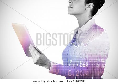 Businesswoman holding digital tablet against stocks and shares 3d