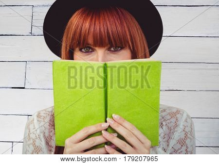 Digital composite of Woman reading against white wood panel