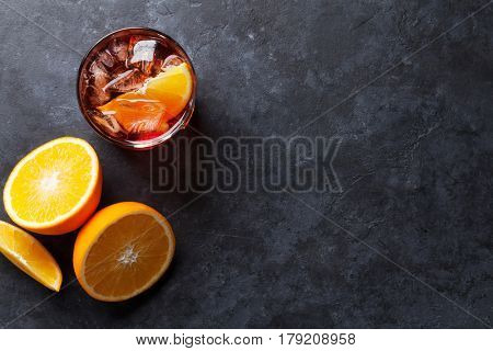 Negroni cocktail on dark stone table. Top view with space for your text