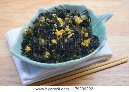 Chinese Traditional Food, Stir Fried Jute Leaves or Mulukhiyah Leaves with Garlics and Fermented Soy Bean.