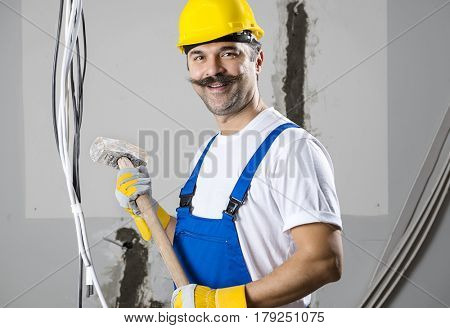 Construction worker holding sledgehammer at a real construction site.   