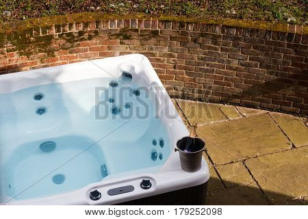 bottle of champagne cooling by hot tub 