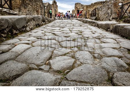 POMPEII, ITALY - MAY 13, 2014: The ancient street. Pompeii is an ancient Roman city died from the eruption of Mount Vesuvius in 79 AD.