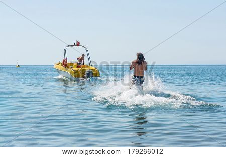 Young man glides on water skiing on the waves on the sea ocean. Healthy lifestyle. Positive human emotions feelings joy.