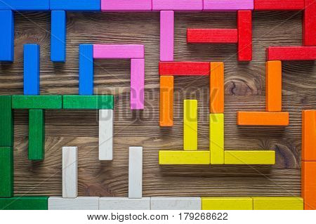 Colorful maze on brown background. The concept of a business strategy analytics search for solutions the search output. Labyrinth of colorful wooden blocks top view flat lay.