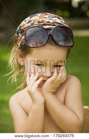The little girl wears a large adult sunglasses Asian-mestizo