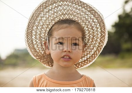 Asian girl of mixed blood in the summer hat the natural background