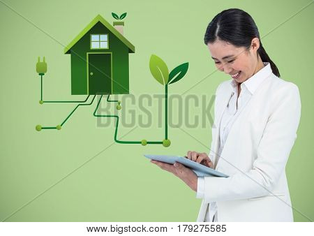 Digital composite of Woman with tablet and green house graphic against green background