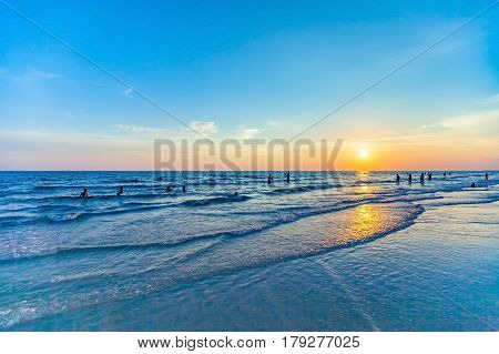 beautiful sunset at the sea with people silhouette on the beach and colorful shading of sunlight and sky