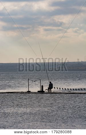 Sihouette of a fisherman at sunset on Siutghiol Lake, Constanta, Romania