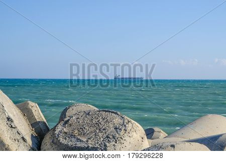 Looking out to sea from  Zygi 's marina, showing a ship passing on the horizon.