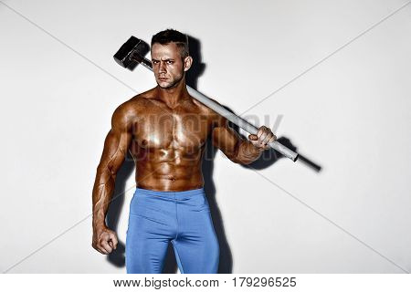 athlete and hammer. guy with a nice muscle fitness, bodybuilder hold big metal hammer