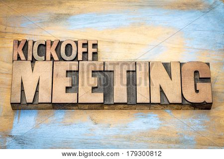 Kickoff meeting word abstract in letterpress wood type printing blocks against grunge wooden surface