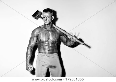 athlete and hammer. guy with a nice muscle fitness, bodybuilder hold big metal hammer