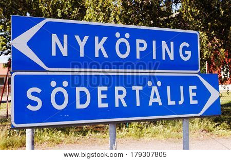 Swedish road sign post with directional signs to the two towns Nykoping and Sodertalje.