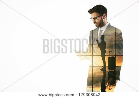 Attractive young bearded man using mobile phone on abstract airport background. Travel concept. Double exposure