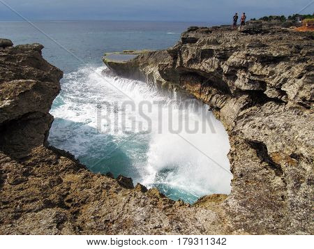 Nusa Lembongan Indonesia - 14 February 2013: People looking at the waves of the sea at Devil's tear on Nusa Lembongan island Indonesia