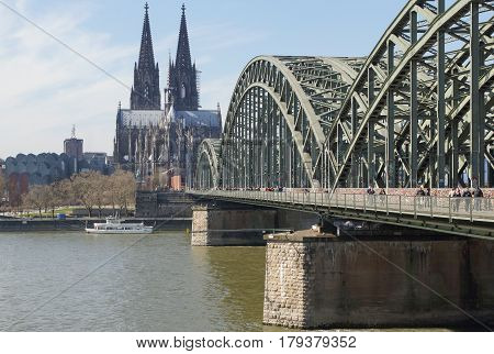 COLOGNE, GERMANY - MARCH 23, 2017: People walking along the Love Lock Gallary with the Cologne Dome in the background on March 23, 2017 in Germany, Europe