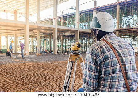 Surveyor worker make measuring with theodolite equipment at factory construction site.
