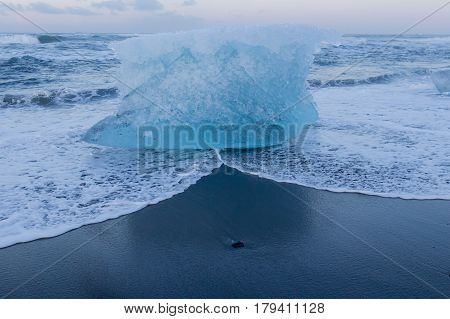 Ice breaking on black sand beach Iceland winter landscaep background